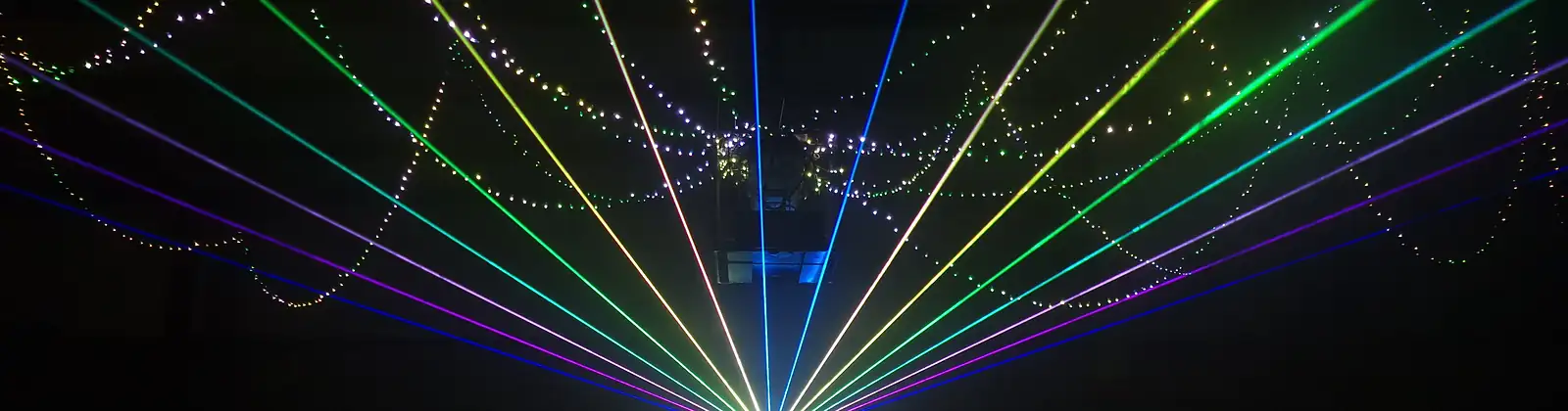 Einzelner Laserprojektor wirft 13 gestochen scharfe Strahlen im gesamten Farbspektrum vor schwarzem Hintergrund